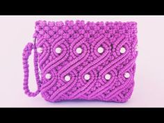 a crocheted purple purse with white buttons