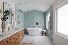 a bath room with a tub a sink and a mirror on the wall next to a window