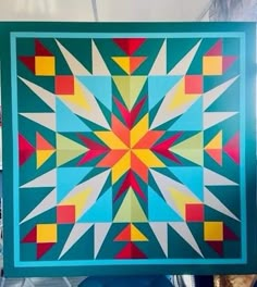 a colorful quilt is hanging on the wall