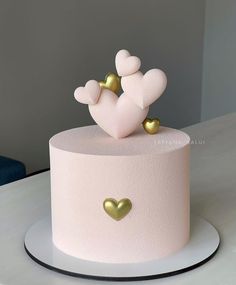 a pink cake with gold hearts on top