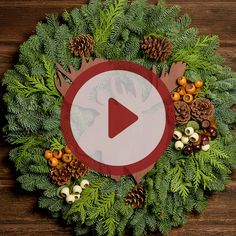 a christmas wreath with pine cones, berries and other holiday decorations on top of it