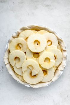 sliced apples in a pie dish on a white table top view from above with space for text