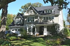 a large gray house with white trim on the front and side of it's windows