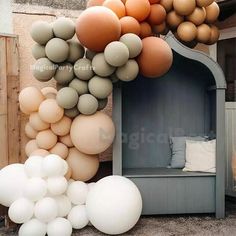 a bunch of balloons that are in front of a building with a bench and pillows