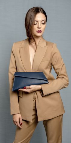 Beautiful and unique leather clutch with detachable short gold high quality chain. The bag is simple, it has modern shape. It can be carried by hand, on the shoulders. Also it is suitable for many outfits. All our bags are handcrafted in small workshop in Poland, where work peaple with big experience. It has embossed logo at the bottom of the bag. It has one pocket, closed with zipper. Interior is lined with high quality fabric. The flap is fastened with magnetic. READY TO SHIP: 2 DAYS Metallic Dark Blue Bag Outfit, Modern Blue Evening Bag, Modern Blue Leather Clutch, Chic Business Clutch With Chain Strap, Chic Business Clutch With Removable Pouch, Blue Leather Chic Clutch, Elegant Business Clutch With Chain Strap, Modern Blue Clutch For Formal Occasions, Blue Chic Leather Clutch