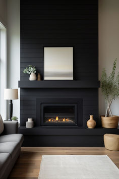 a living room with black walls and a fire place in the center, along with a white rug on the floor