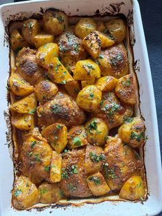 a casserole dish with potatoes and parsley on top, ready to be eaten