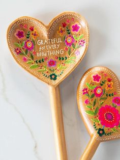 two wooden spoons decorated with colorful flowers and the words grateful for every thing on them