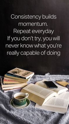 an open book sitting on top of a pile of books next to a cup of coffee