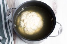 cauliflower is cooking in a pot on the table