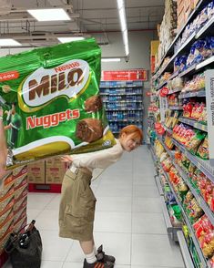 a woman holding a bag of chips in a grocery store