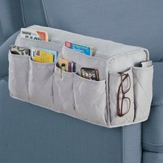 an over - the - seat organizer holds books, magazines and eyeglasses