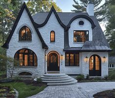 a white brick house with arched windows and steps leading up to the front door area