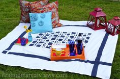 the picnic blanket is laid out on the grass with some drinks and other items sitting on it