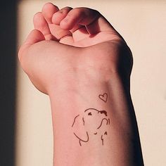 a small elephant tattoo on the arm of a woman's left arm and wrist