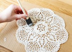 a person is using a pencil to draw a doily