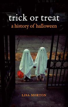 two people in white ghost costumes standing behind gates