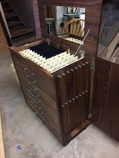 a wooden cabinet with many drawers and mirrors on it's sides in a shop