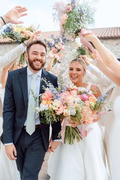 a bride and groom are walking through confetti thrown by their guests at the wedding