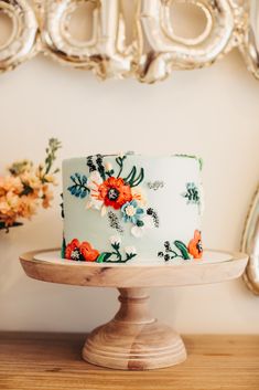 a blue and white floral cake sitting on top of a wooden table