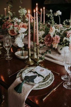 the table is set with flowers and candles