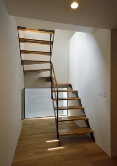 a stair case in an empty room with wooden floors