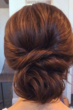 the back of a woman's head with brown hair in a low updo