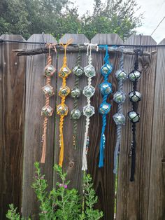 there are many ornaments hanging on the fence