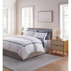 a bed with white and blue comforters in a bedroom