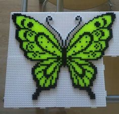 a green butterfly made out of legos sitting on top of a table