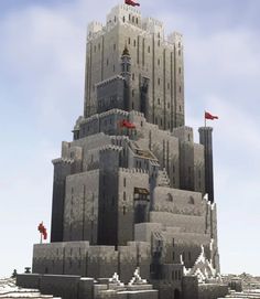 a very large castle made out of sand with flags flying in the sky above it