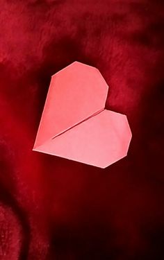 an origami heart on a red background