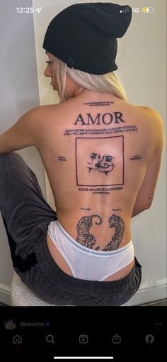 the back of a woman's body with tattoos on it