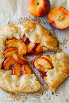 a peach pie with one slice cut out and two pieces removed from it on a piece of parchment paper