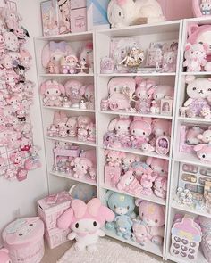 a room filled with lots of pink and white stuffed animals next to bookshelves