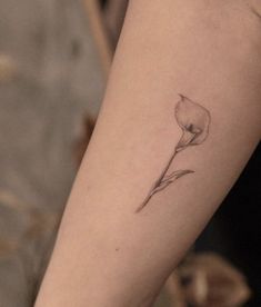 a single flower tattoo on the arm