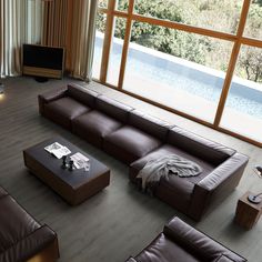 a living room with large windows and leather furniture