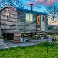 a small wooden house sitting on top of a lush green field