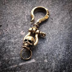 a gold skull keychain is laying on the ground