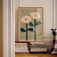 there is a painting on the wall next to books and a vase with flowers in it