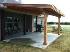 a covered patio with chairs and an outdoor bbq