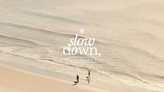 two people are walking on the beach with their surfboards in hand and an inscription above them that says slow down