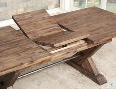 a wooden table sitting in front of a window with two pieces of wood on it