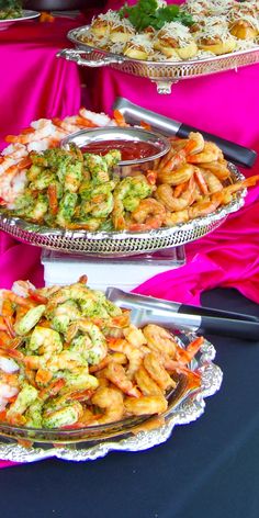 three platters filled with different types of food on top of a blue table cloth