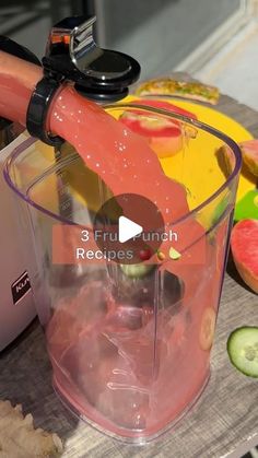 a blender filled with fruit on top of a wooden table