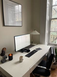 a desk with a computer, keyboard and mouse on it in front of a window