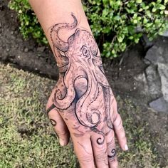 a hand with an octopus tattoo on it's left arm and the other hand