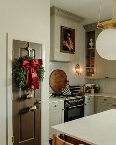 a kitchen decorated for christmas with wreath on the door