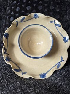 a blue and white bowl sitting on top of a black couch