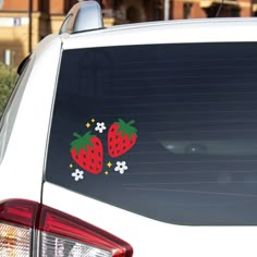 two strawberries stickers on the back of a car